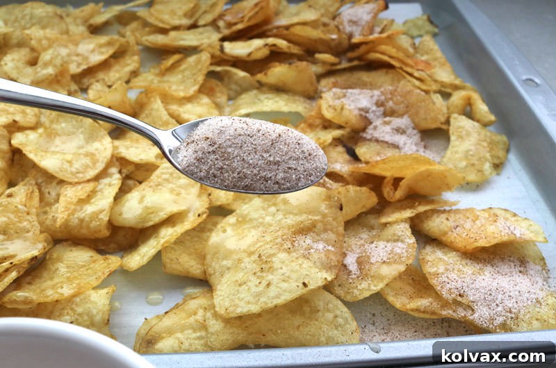 Sprinkling the freshly mixed cinnamon sugar over butter-coated Kettle Chips.