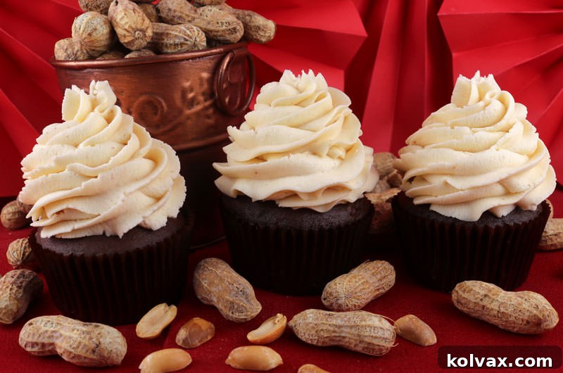 Delicious Peanut Butter Whipped Cream Frosting generously piped onto cupcakes and a cake, showcasing its beautiful texture and rich color. A perfect balance of light whipped cream and creamy peanut butter flavor, ideal for any celebration.