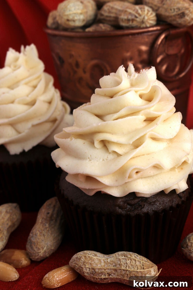 Close-up of a cupcake generously topped with The Best Peanut Butter Whipped Cream Frosting, highlighting its appealing texture and tempting appearance, ready to be enjoyed.