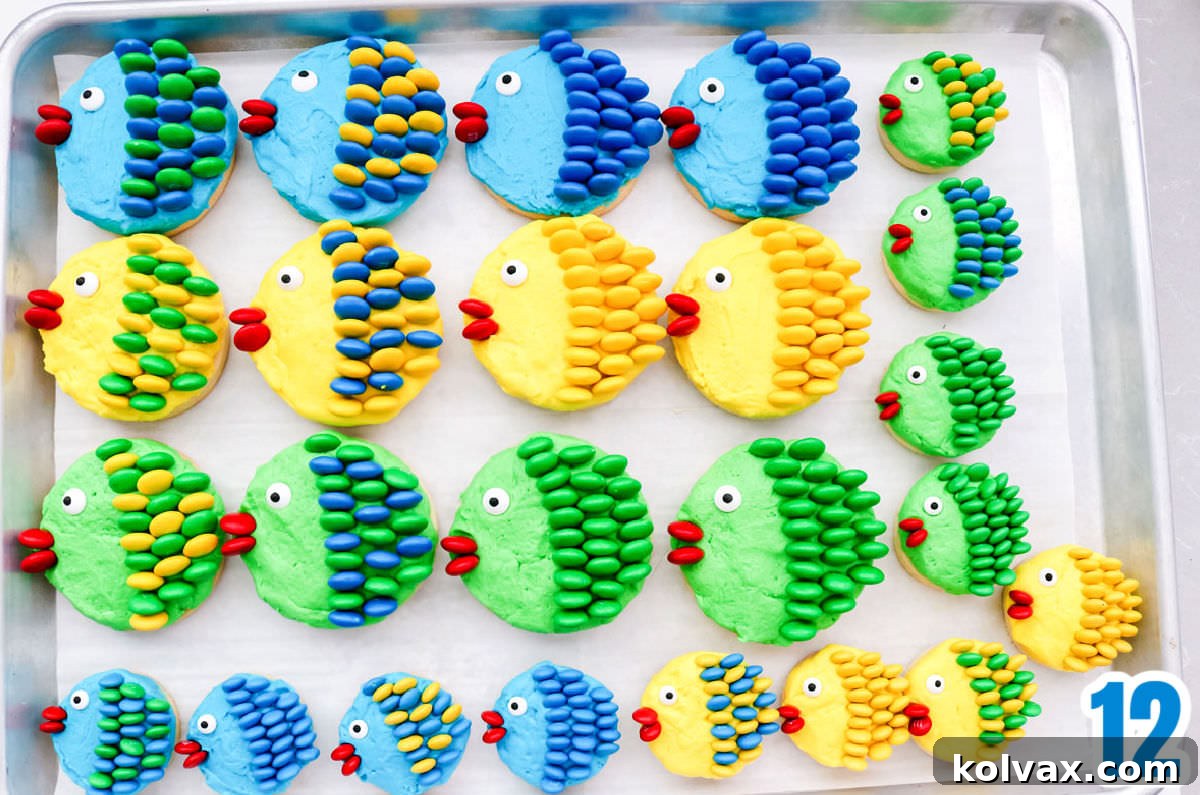 An overhead shot of a baking sheet filled with an assortment of beautifully decorated Under the Sea M&M Cookies in various colors and sizes, showcasing their individuality.