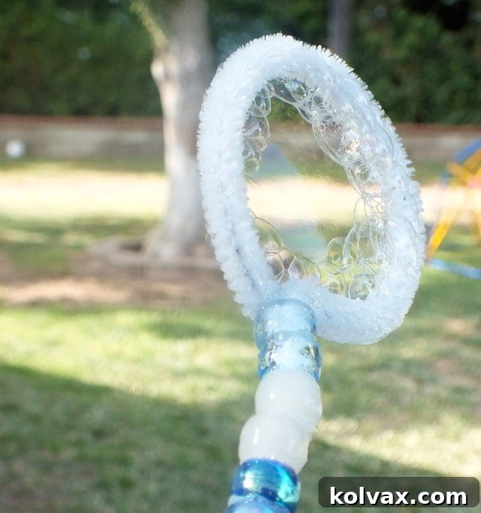 A child joyfully uses a handmade DIY Bubble Wand, demonstrating its effectiveness in creating wonderful bubbles at the Frozen-themed party.