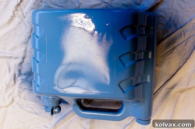 Spray painting the cleaned detergent container blue for a Frozen theme