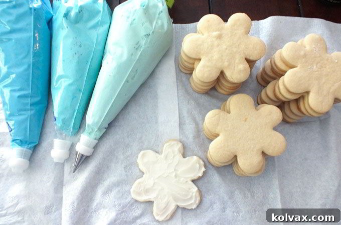 Preparing the buttercream frosting for the snowflake sugar cookies, including white and various shades of blue for an ombre effect.