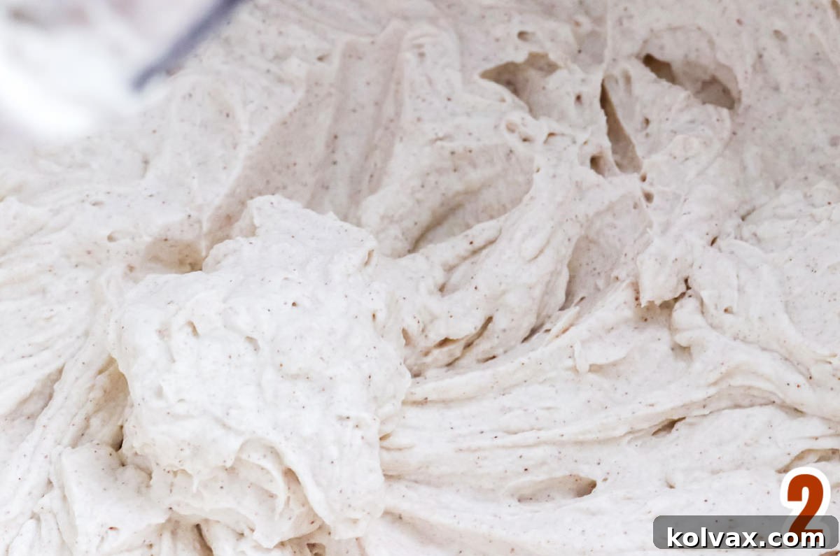 A delicious close-up of a mixing bowl filled with freshly made, perfectly textured Homemade Cinnamon Whipped Cream, ready to be served.