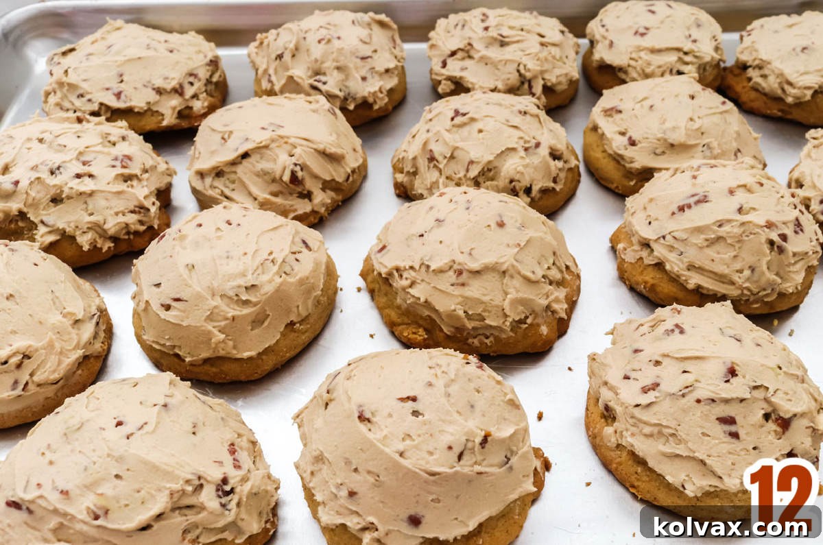 Cookie sheet filled with neat rows of beautifully Frosted Sweet Potato Cookies, each topped with creamy Maple Pecan Frosting.