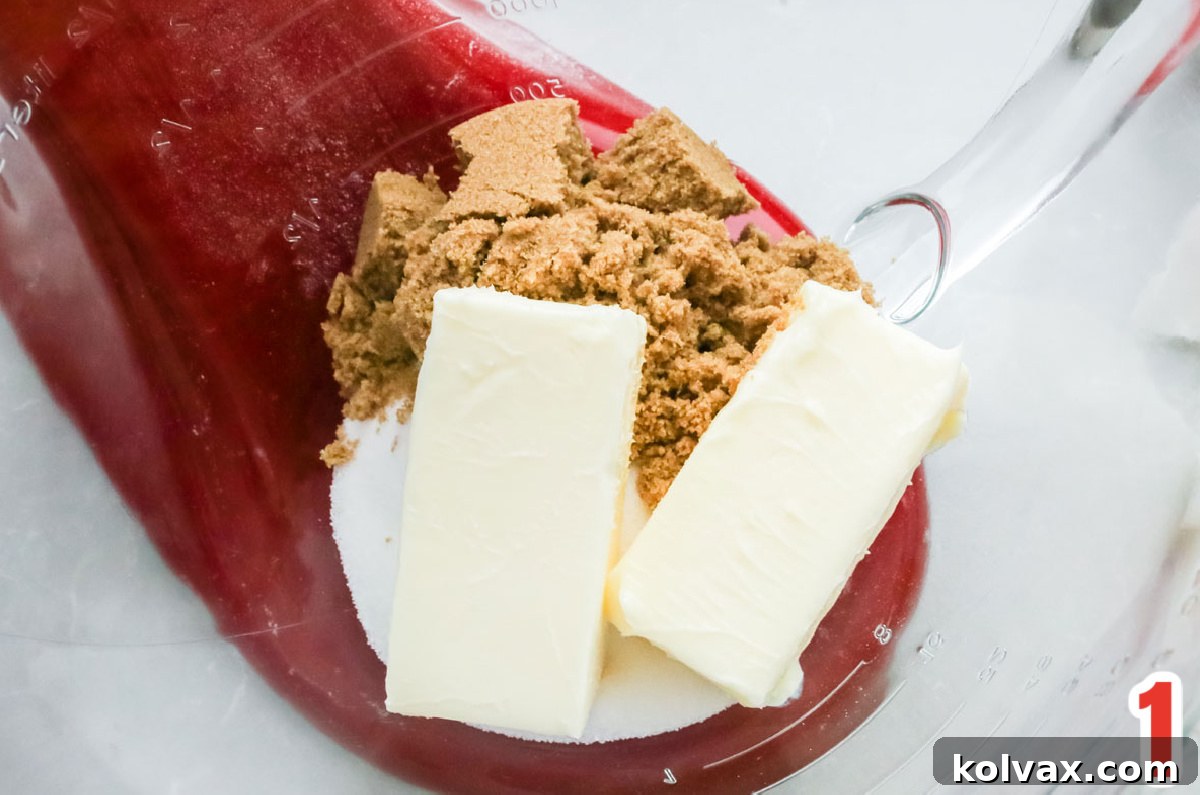 Closeup on butter, granulated sugar and brown sugar in a glass mixing bowl.