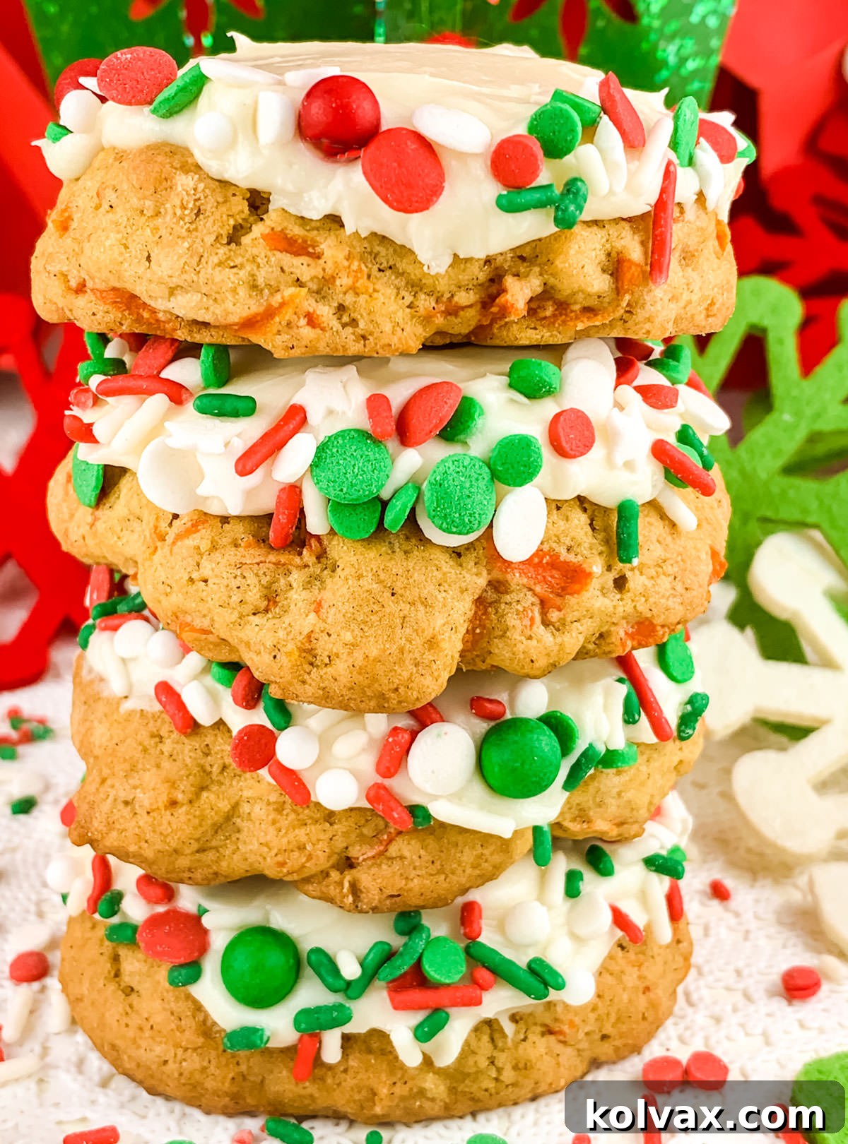 Close up on a stack of four Christmas Carrot Cake Cookies sitting on a white table in front on Christmas decorations.