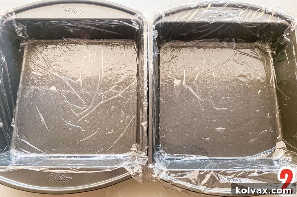 Two 8x8" pans lined with plastic wrap.