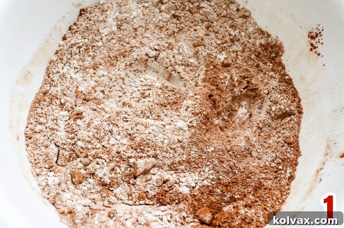 White mixing bowl filled with all-purpose flour and rich unsweetened cocoa powder, perfectly blended for chocolate crinkle cookies.