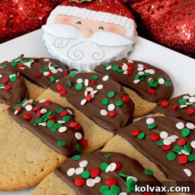 Peanut Butter Cookies partially dipped in chocolate and adorned with festive sprinkles.