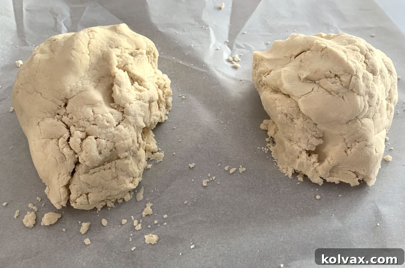 Two neatly formed balls of plain butter cookie dough on a surface, ready for coloring.