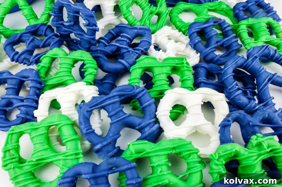 Closeup on a full batch of Seattle Seahawks Pretzels in Blue, Green and White laying randomly on a white table.