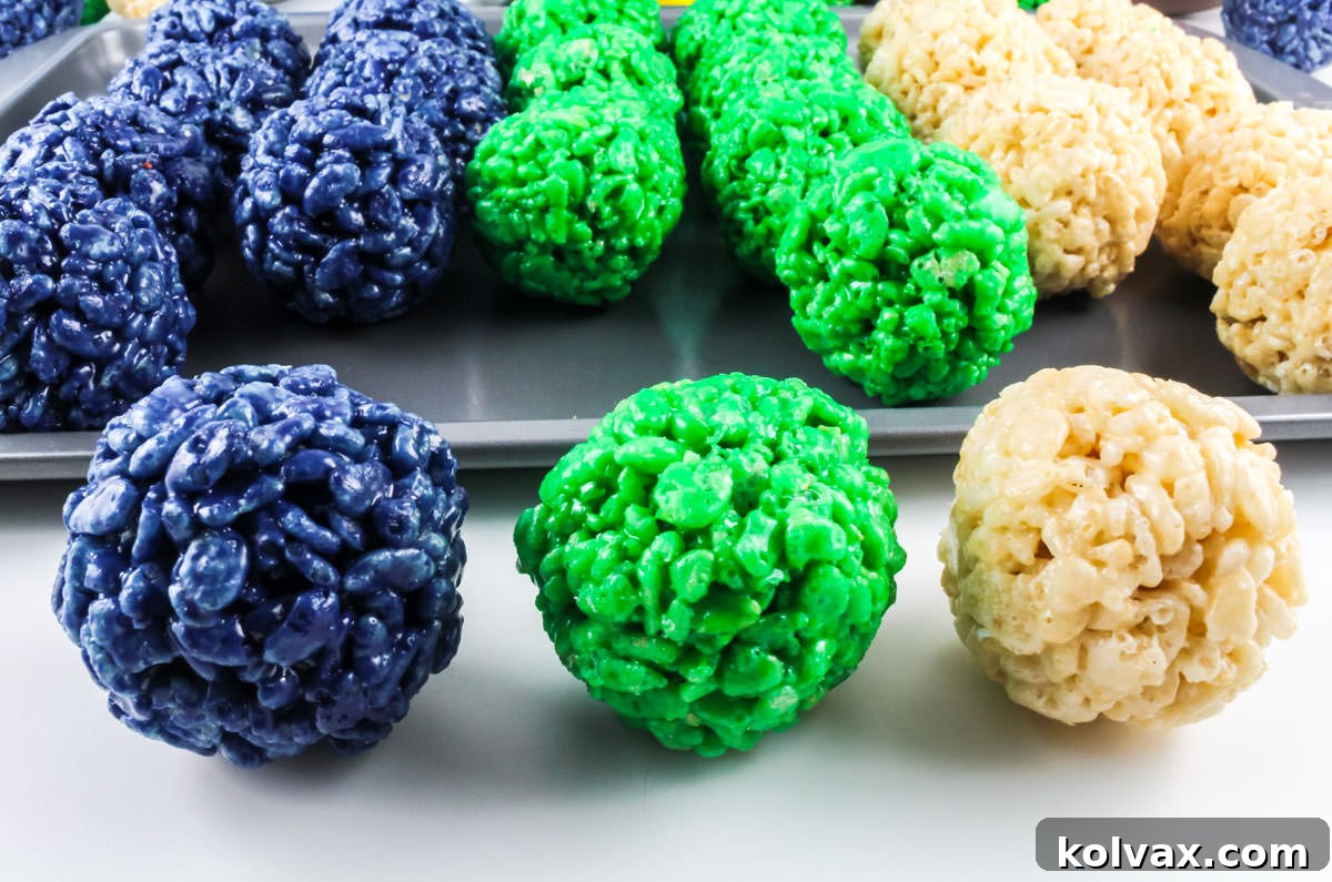 Closeup on three perfectly formed Rice Krispie Bites in Seattle Seahawks team colors: Navy Blue, Action Green, and Crisp White.