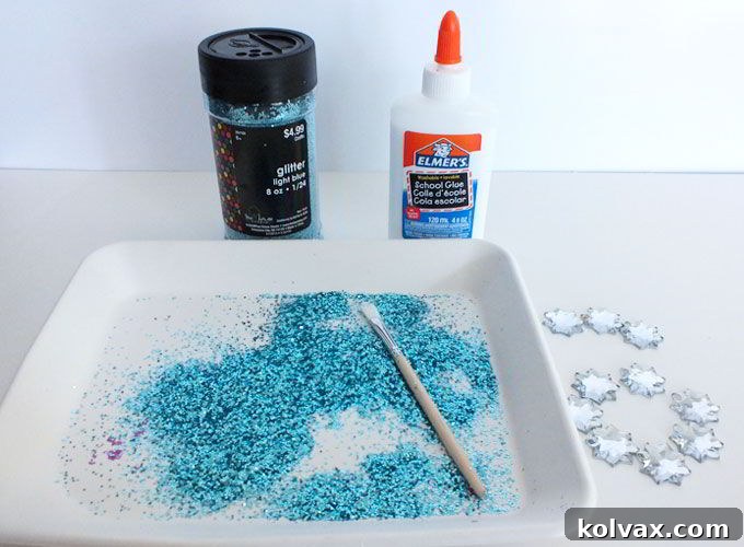 Preparing the Elsa Crown for embellishment by applying Elmer's glue to its edges for glitter.
