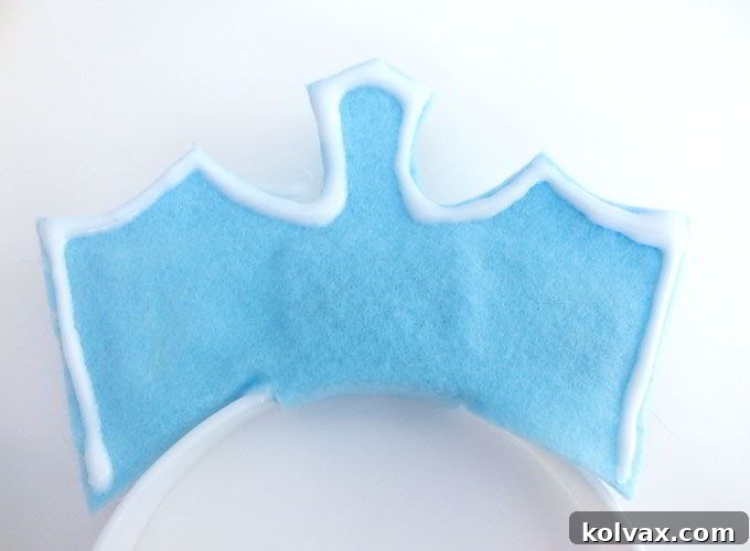 Applying a bead of Elmer's glue carefully along the entire edge of the felt crown.