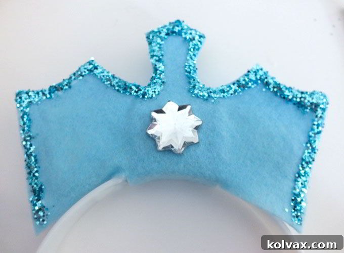 Adhering a large snowflake-shaped rhinestone to the center front of the Frozen Elsa Crown.