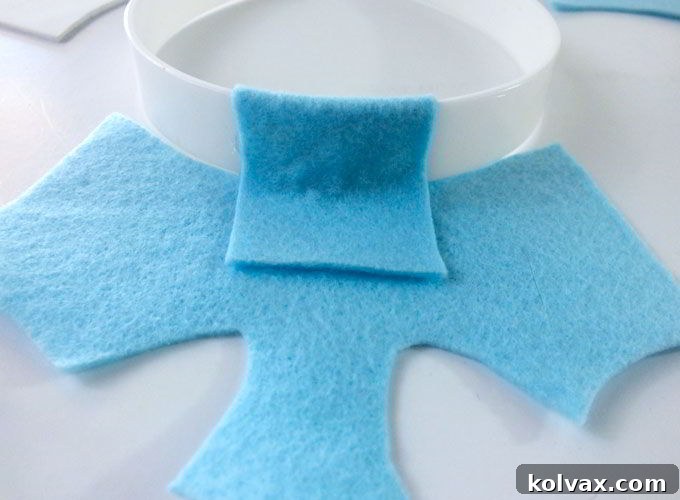 The process of finishing the gluing of the front crown piece to the headband, ensuring all sides of the tab are secure.