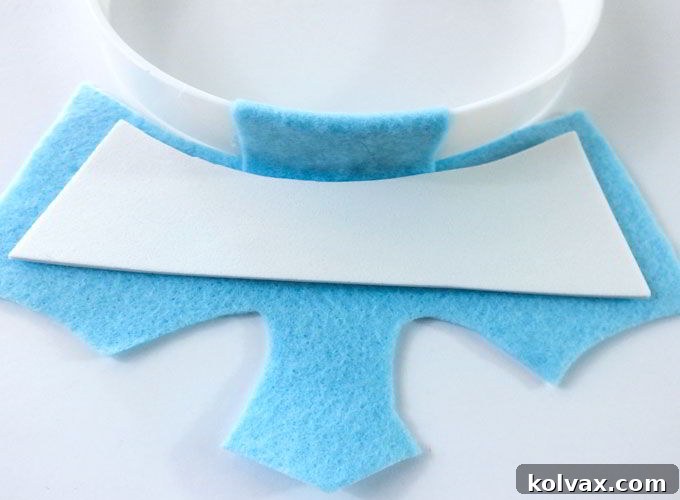 Attaching the thin foam crown insert to the back of the felt crown piece to provide structural support.