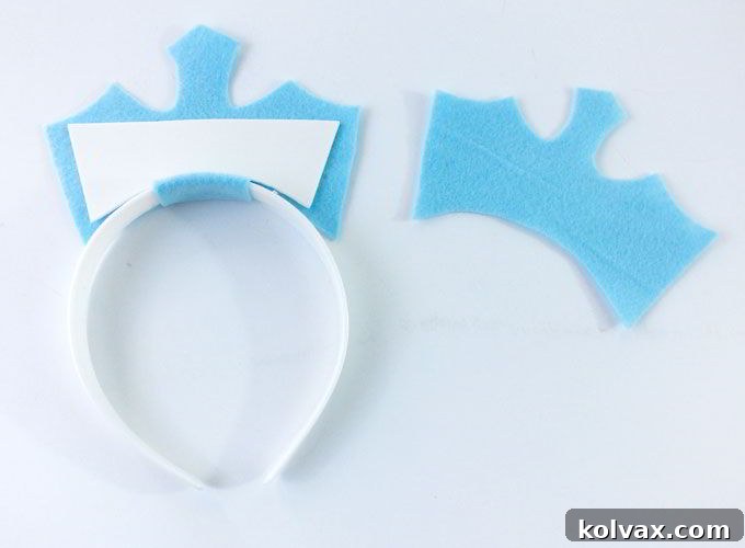 Using a glue gun to cover the foam insert with the back felt piece, creating a complete and sturdy crown.
