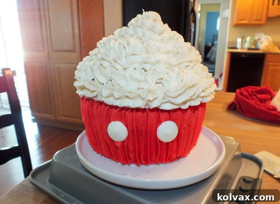 Mickey Mouse Celebration Cupcake Cake 6 Adding bright white Wilton Candy Melts as iconic buttons to the red bottom half of the Mickey Mouse Cupcake Cake.