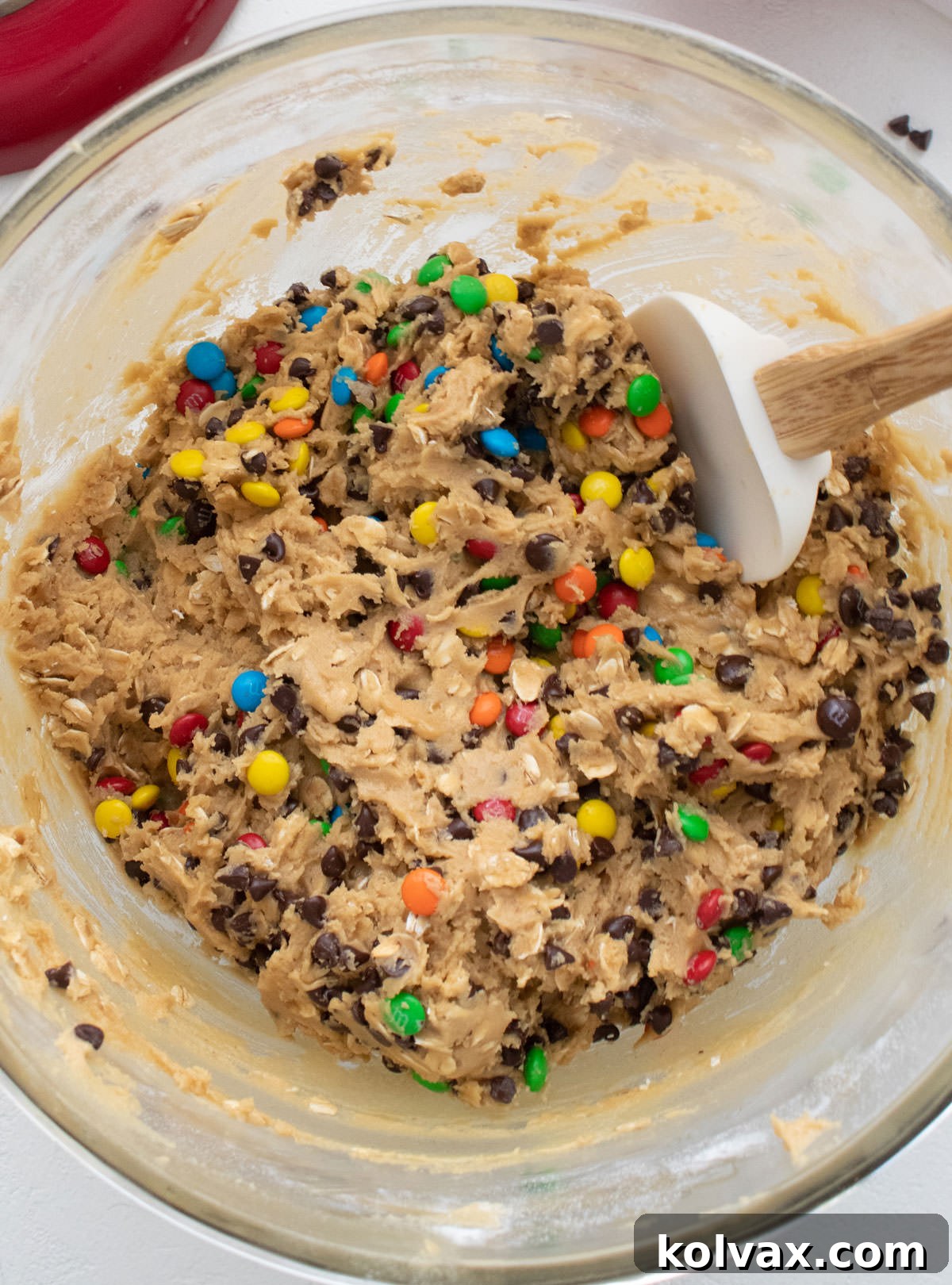 Ultimate Soft and Chewy Monster Cookies 3 Glass mixing bowl filled with the rich and chunky cookie dough for a batch of Monster Cookies, ready for baking.