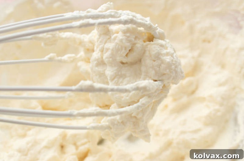 Freshly made whipped cream in a glass bowl, light and fluffy.