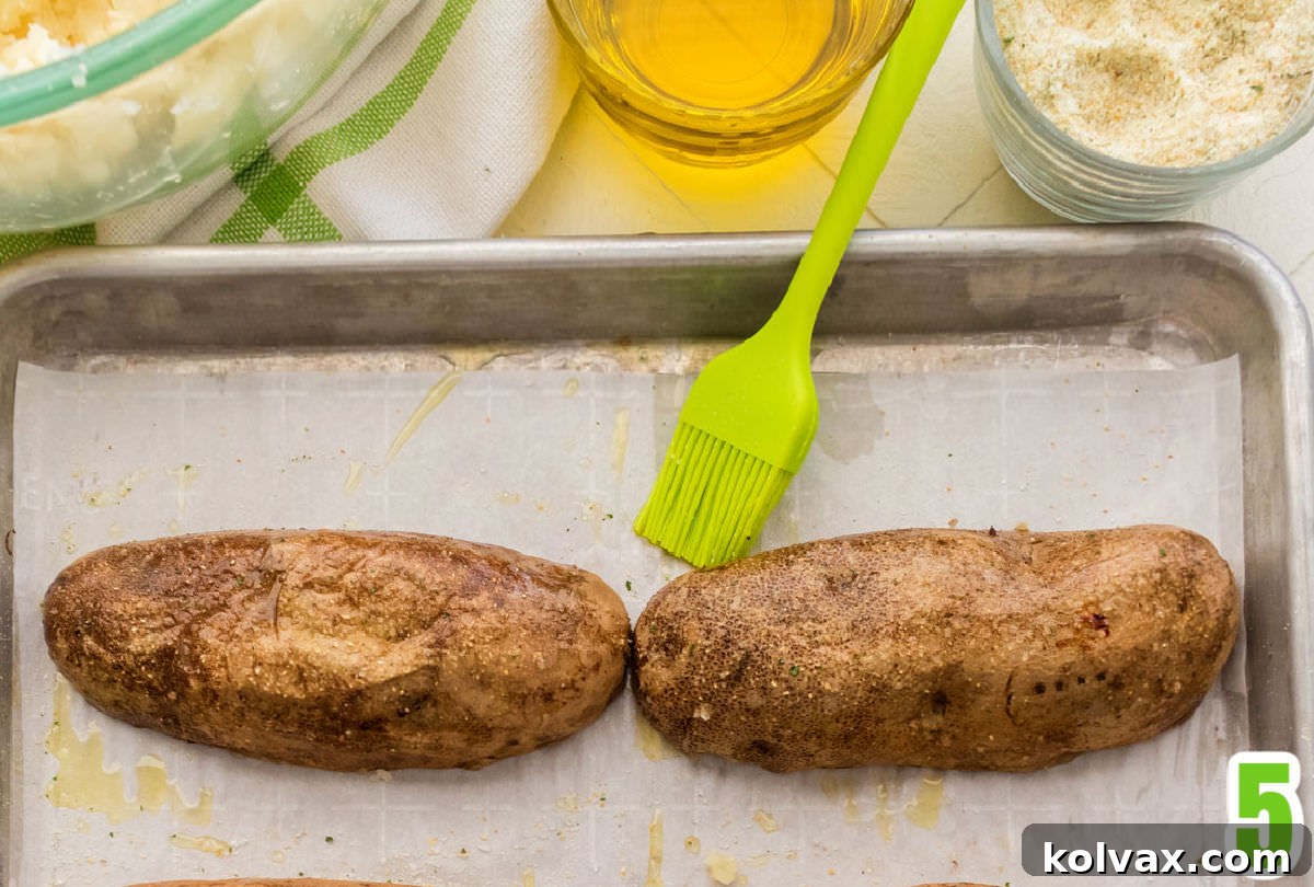 Creamy Stuffed Potato Perfection 4 Closeup of a baked potato shell, upside down on a cookie sheet ready to go back in the oven after being lightly brushed with olive oil.