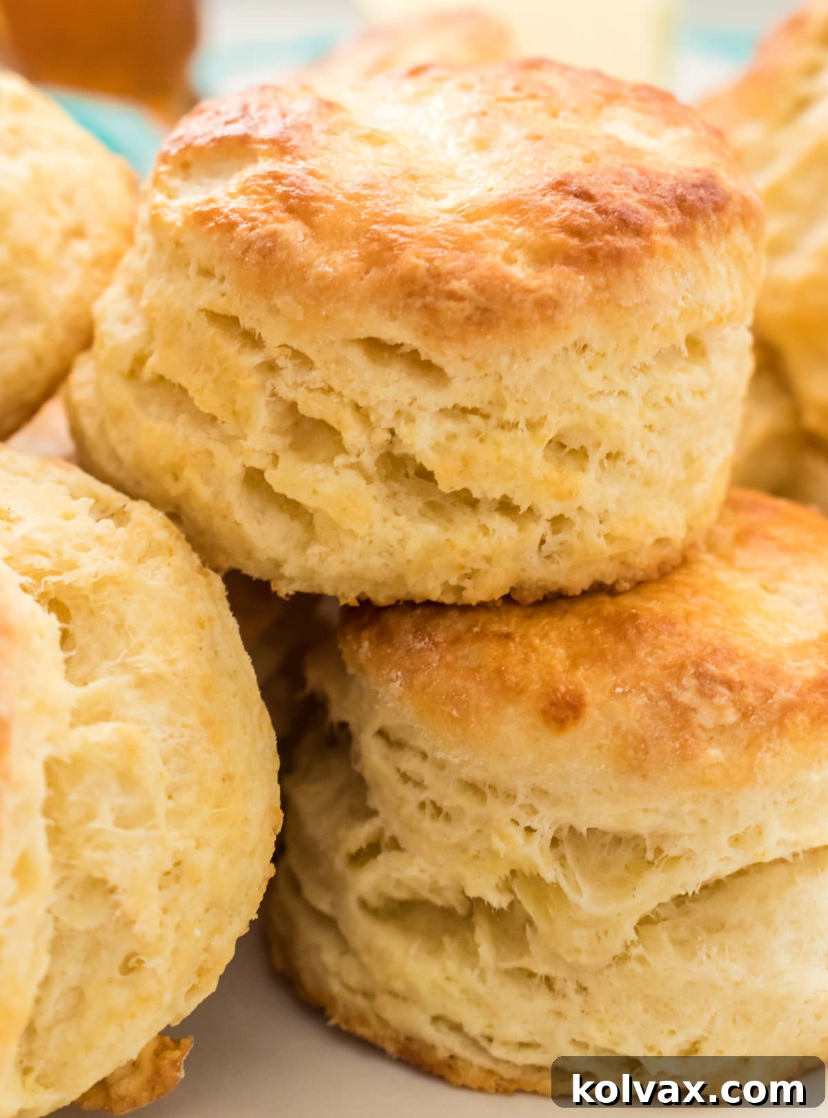 Closeup on a stack of golden-brown Homemade Buttermilk Biscuits, freshly baked and ready to be served, highlighting their tall and fluffy appearance.