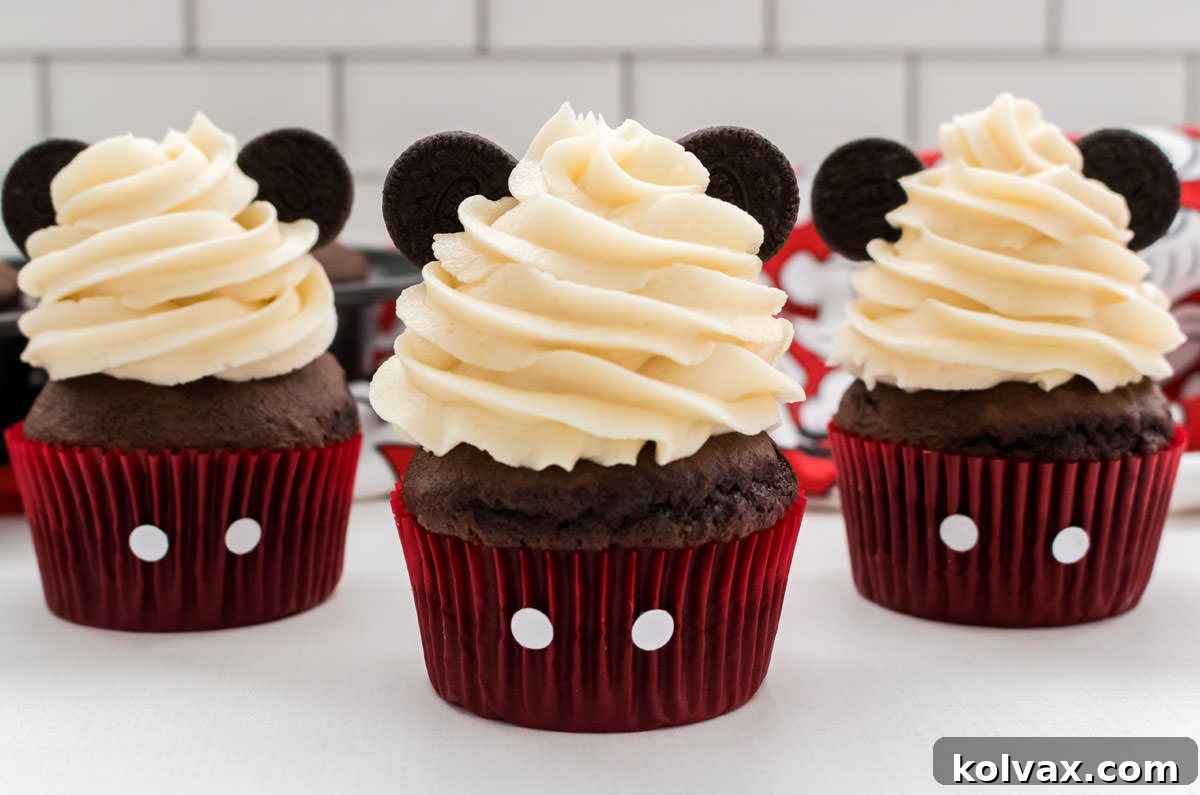Three perfectly decorated Mickey Mouse Cupcakes with creamy buttercream, red liners, and classic Oreo ears, ready for a Disney party.