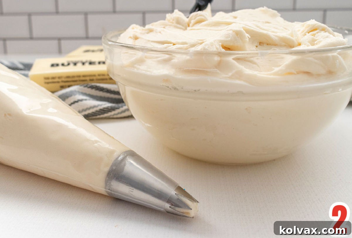 A bowl of creamy homemade buttercream frosting next to a piping bag, ready to adorn delicious Mickey Mouse Cupcakes.