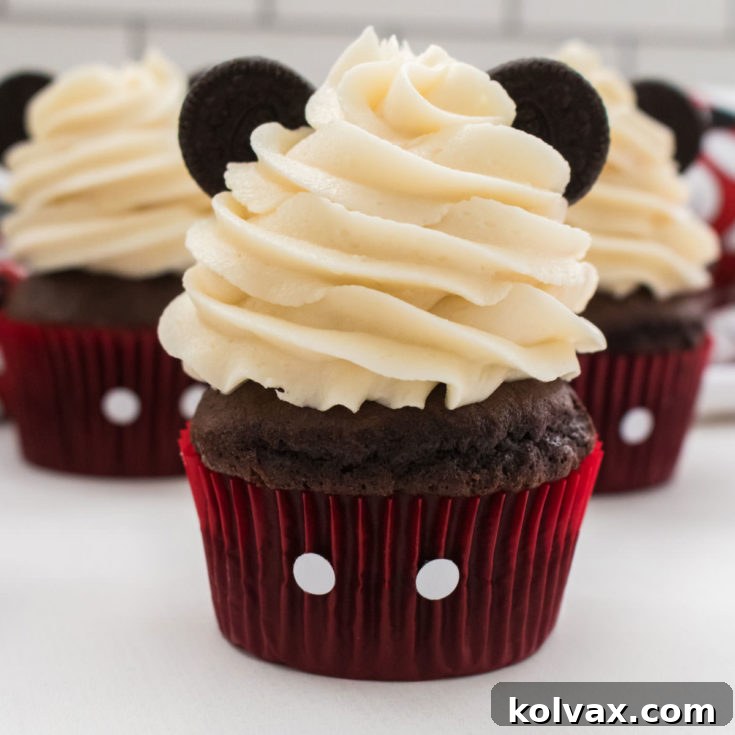Mickey Mouse Cupcakes with red liners, buttercream, and Oreo ears on a white surface.