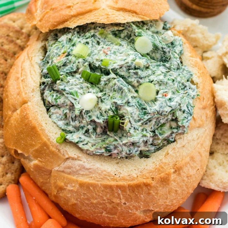 Spinach Dip served in a bread bowl with dippers.