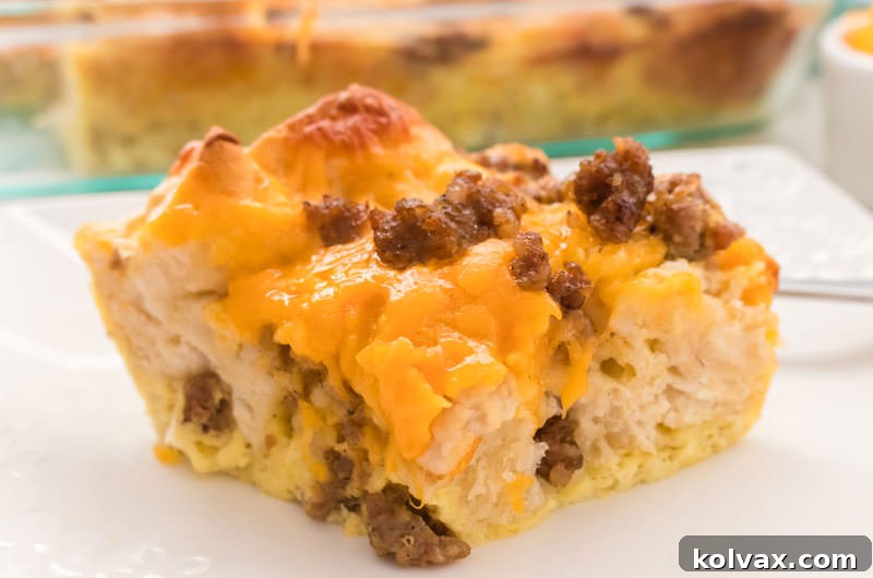 A perfectly portioned slice of Sausage Egg Biscuit Casserole, showcasing the fluffy biscuits, savory sausage, and melted cheese, ready to be enjoyed.