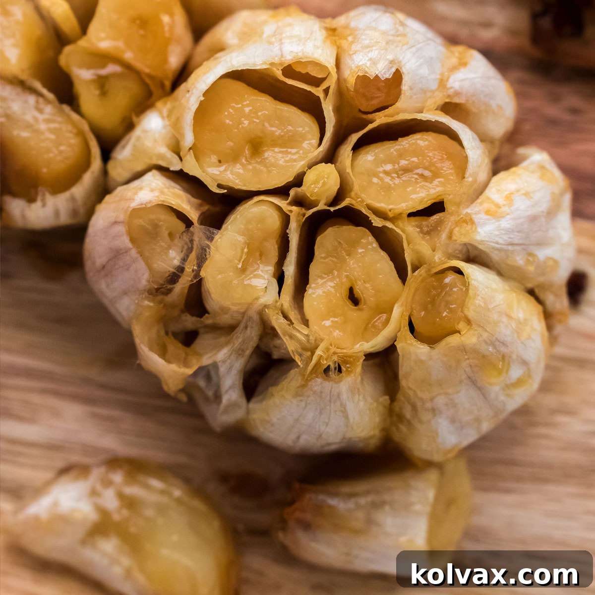 Closeup overhead shot of a roasted head of garlic sitting on a cutting board.