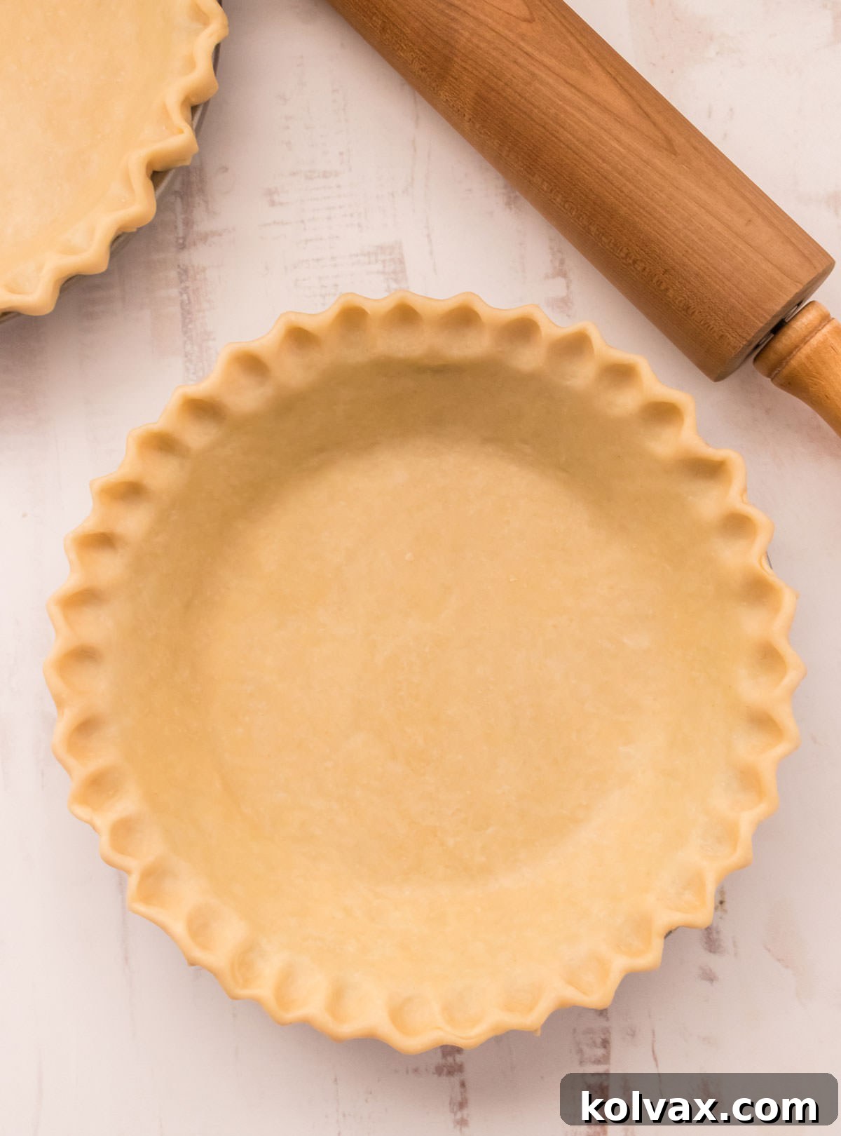 Picture of a pie crust ready to be filled and go in the oven, showcasing the beautiful crimped edge.