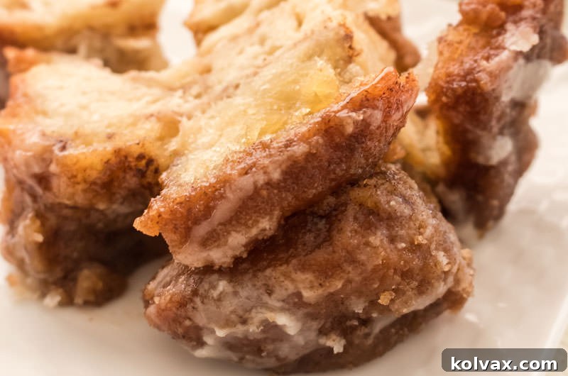 Close-up of a portion of baked Monkey Bread on a serving plate, showing its warm, gooey texture and cinnamon-sugar coating.