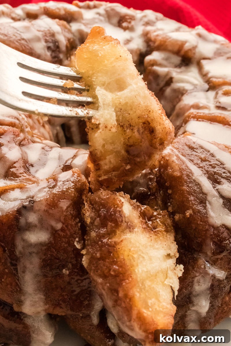 A wide shot of a baked Monkey Bread on a rustic wooden board, garnished with fresh berries and coffee, ready for serving.