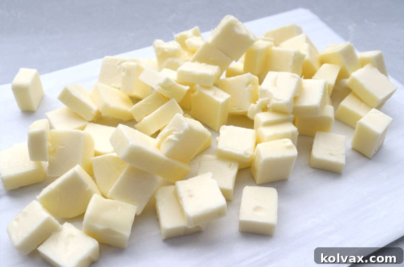 High-quality unsalted butter, cubed and ready to be transformed into nutty brown butter on a clean cutting board.