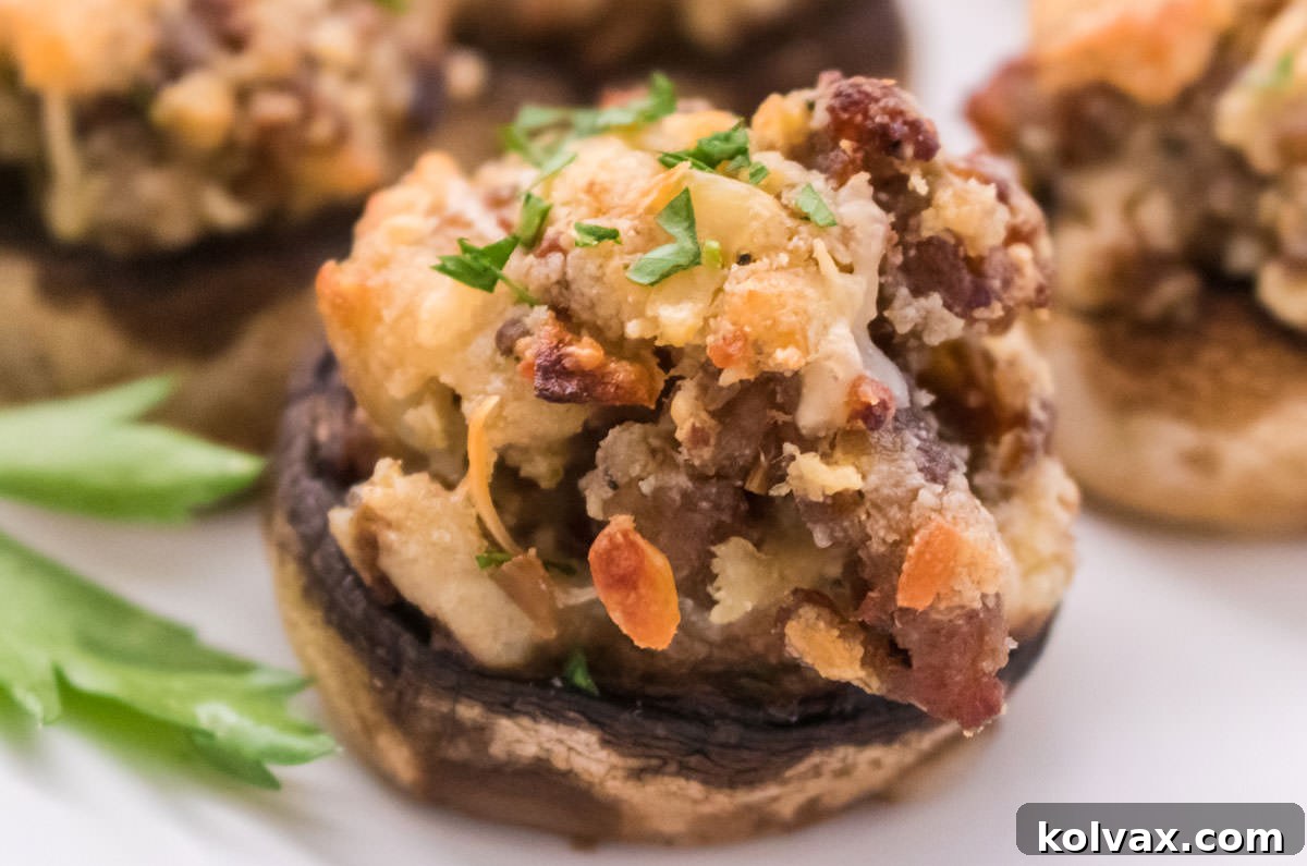 Closeup of a perfectly baked Stuffed Mushroom, golden brown and cheesy, resting on a pristine white serving platter.