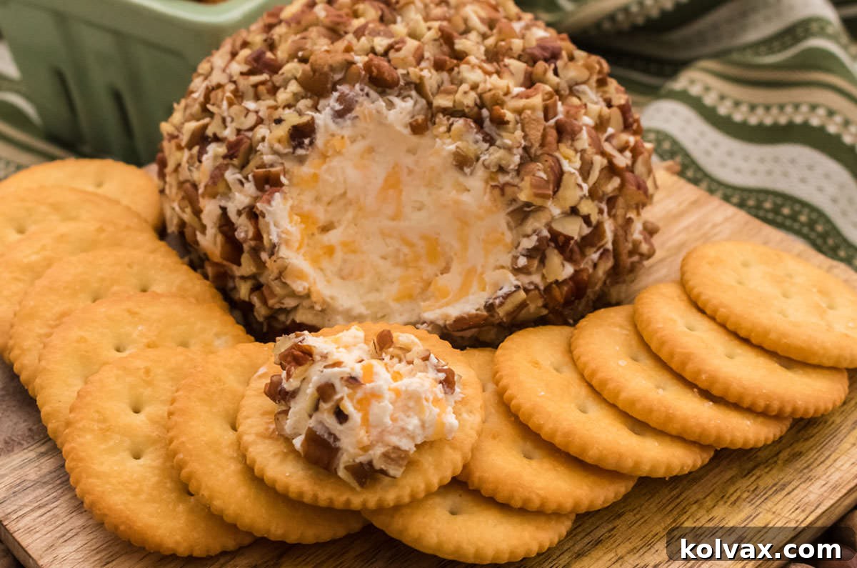 Delicious Pecan Cheese Ball appetizer garnished with crunchy pecans, served on a rustic wooden board with Ritz crackers.