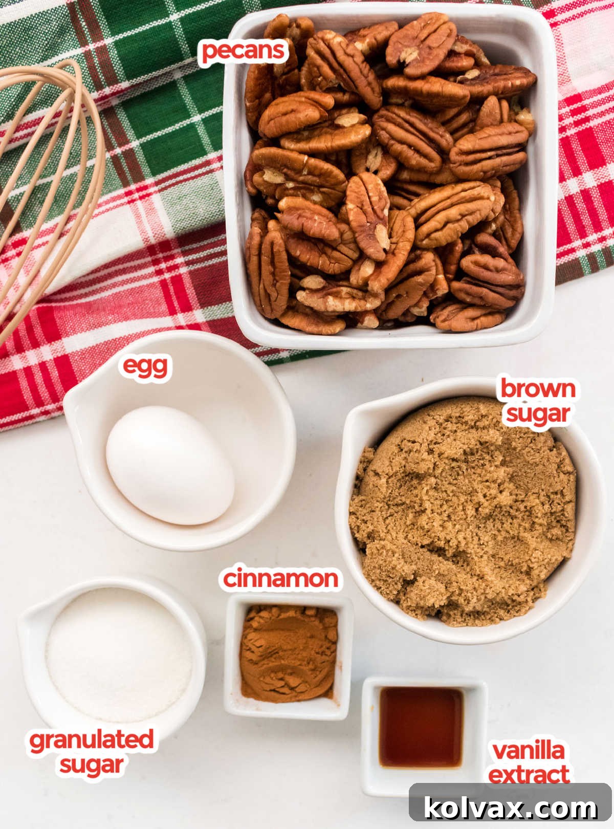 All the ingredients necessary to make Candied Pecans including Pecans, Granulated Sugar, Brown Sugar, Egg, Cinnamon and Vanilla neatly arranged on a wooden surface.