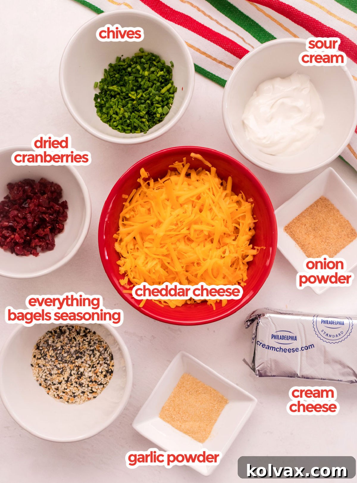 Golden Cheese Puffs 3 All the essential ingredients neatly arranged for making Cheese Ball Bites, including blocks of cream cheese, a tub of sour cream, shredded cheddar cheese, various spices, and a selection of colorful toppings.