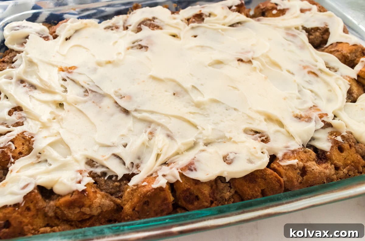Close up of the Cream Cheese Frosting covering a pan of Cinnamon Roll Breakfast Casserole.