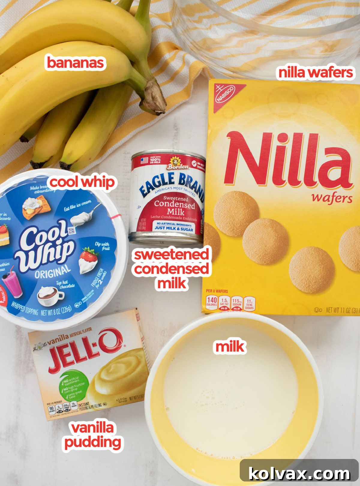 An assortment of all the key ingredients laid out for making Banana Pudding, including fresh bananas, Nilla Wafers, milk, instant vanilla pudding mix, sweetened condensed milk, vanilla extract, and Cool Whip.