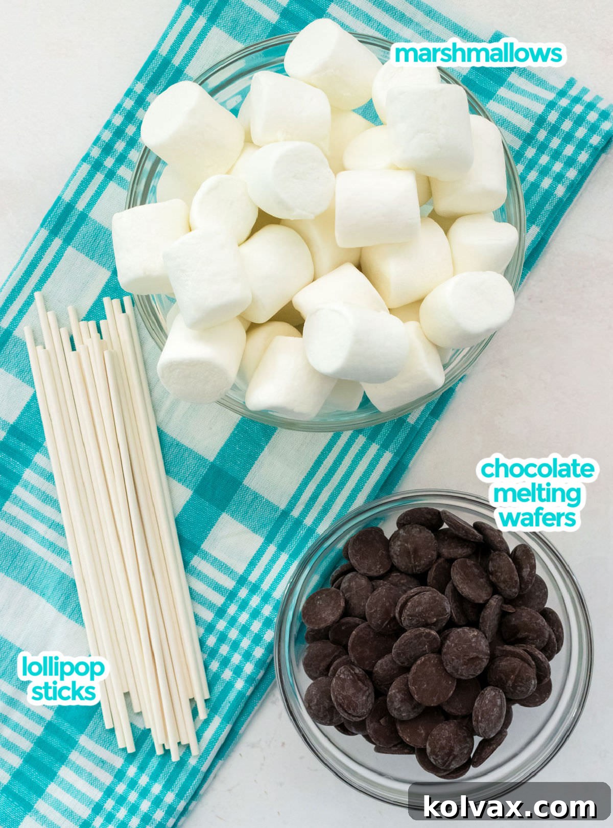 All the essential ingredients neatly laid out for making Marshmallow Pops: fluffy marshmallows, rich chocolate melting wafers, and sturdy lollipop sticks, ready for assembly.
