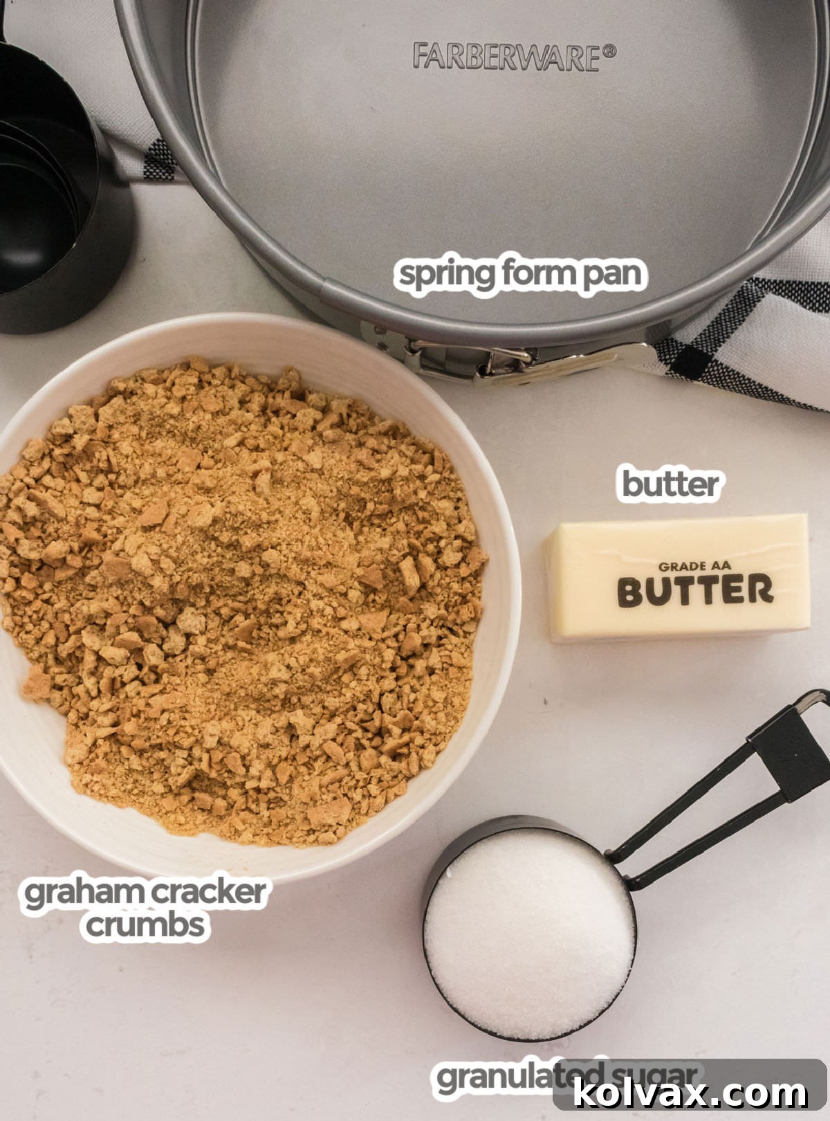 All the ingredients required to make a Graham Cracker Crust including graham cracker crumbs, butter, sugar and a springform pan.