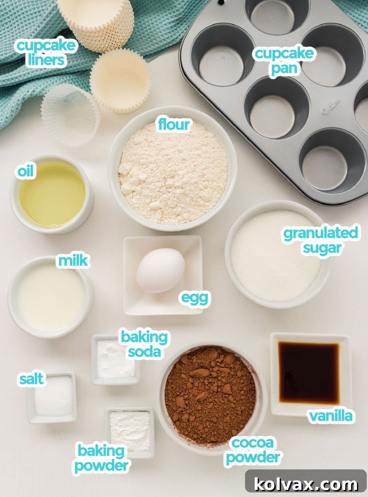 All the ingredients needed to make Homemade Chocolate Cupcakes including cupcake liners, a cupcake pan, flour, sugar, cocoa powder, oil, milk, egg, vanilla, baking soda, baking powder and salt.