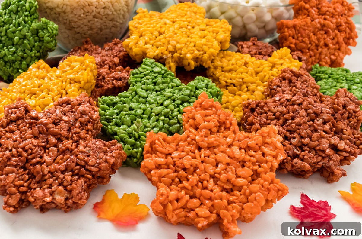 Autumn Foliage Rice Krispie Bars 2 A festive arrangement of colorful Fall Leaves Rice Krispie Treats on a white table, surrounded by mini marshmallows and Rice Krispie cereal, highlighting their vibrant autumn hues.