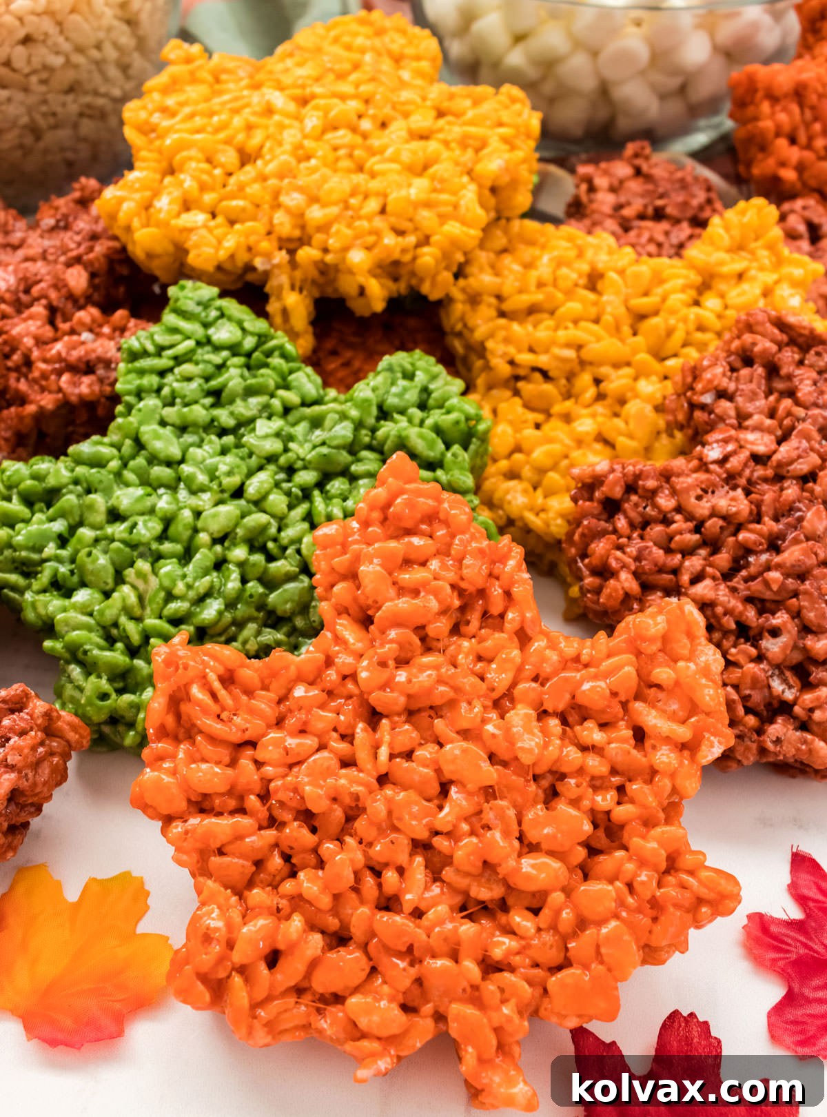 Autumn Foliage Rice Krispie Bars 8 A beautiful display of Fall Leaves Rice Krispie Treats arranged on a white table, adorned with festive autumn leaf decorations, creating a charming seasonal scene.