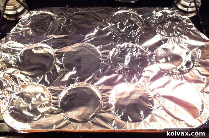 Covering the cupcake pan with aluminum foil for secure cone cup placement